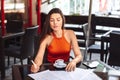 Woman signs documents in a cafe for a cup of coffee. Freelance and remote work. Business lady in a meeting. Happy working girl Royalty Free Stock Photo
