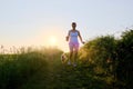 Woman Silhouette with a dog running down a gravel path at sunset Royalty Free Stock Photo