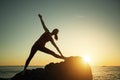Woman silhouette doing yoga exercise on sea beach during sunset Royalty Free Stock Photo