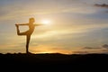 woman silhouette doing yoga outside the house in the evening