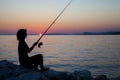 Woman silhouette fishing on rock Royalty Free Stock Photo