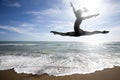 Woman silhouette jumping behind the sea. Sun and beach. Royalty Free Stock Photo