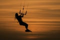 Woman silhouette kiteboarder jumping kitesurfing sport at sunset golden hour Royalty Free Stock Photo