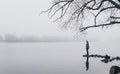 Woman silhouette on the river bank in the morning fog Royalty Free Stock Photo