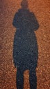 Woman silhouette on the road asphalt paving after an evening rain black gray gravel texture road