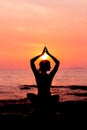 Woman silhouette sitting in lotus position on sea background back lit Royalty Free Stock Photo