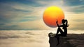 Woman silhouette on top of rock above clouds painting the sun on sky Royalty Free Stock Photo