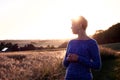 Woman Silhouette at sunset against the sun and a corn field in the background Royalty Free Stock Photo