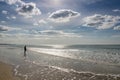 Woman in silhouette in the surf at a wild and empty beach during a beautiful sunrise Royalty Free Stock Photo