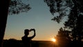 Woman silhouette taking photo of sunset with smartphone Royalty Free Stock Photo