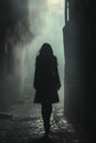 Woman silhouette walking in a dark urban alley at night. Royalty Free Stock Photo