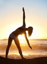 Woman, silhouette and yoga for balance on beach with trikonasana pose for stretching, zen or meditation. Person, shadow Royalty Free Stock Photo