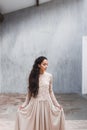 Woman in a silk dress with lace cape on background of gray shabby textured wall Royalty Free Stock Photo