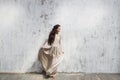 Woman in a silk dress with lace cape on background of gray shabby textured wall Royalty Free Stock Photo