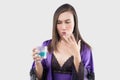 Woman in silk nightgown and purple robe feel burn in her mouth because using mouthwash