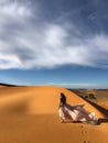 Woman in silk wedding dress with fantastic view of Sahara desert sand dunes Royalty Free Stock Photo