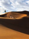 Woman in silk wedding dress with fantastic view of Sahara desert sand dunes Royalty Free Stock Photo