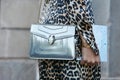 Woman with silver Bulgari bag, golden Cartier bracelets and leopard pattern dress before Luisa Beccaria Royalty Free Stock Photo