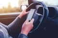 Woman simultaneously driving car and reading text message Royalty Free Stock Photo