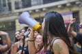 Woman singing, cheering her peers using a megaphone during the feminist strike