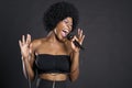 Woman singing on microphone over colored background