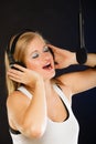 Woman singing to microphone wearing headphones in studio Royalty Free Stock Photo