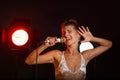 A woman sings a song in the studio