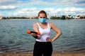 Woman in singular mask do exercises on the beach