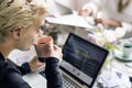 Woman Sipping Coffee while Working on Laptop Royalty Free Stock Photo