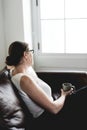 Woman sipping a drink sitting on a couch