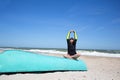 Woman sit at beach on old blue sail boat in lotus padmasana pose with hands and head raise up Royalty Free Stock Photo