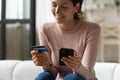 Woman customer holding credit card and smartphone buying online, closeup Royalty Free Stock Photo