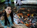 Woman sit beside koi fish pool Royalty Free Stock Photo
