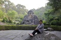 Woman sit before Laozi Statue of qingyuanshan mountain, adobe rgb