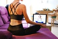 Woman sit in lotus pose meditating using notebook on-line yoga session