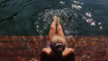 Woman sit on a pier in sunglasses and swimming suit. Girl rest on a flood wood underwater pier. Lady in the water and