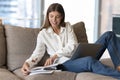 Woman sit on sofa studying or working using computer Royalty Free Stock Photo