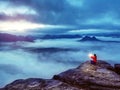 Woman sit on summit in hands holding flash bolb. Girl waiting