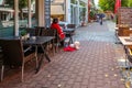 A female customer and her dog at a sidewalk cafe in Germany.