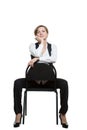 Woman sits astride a chair. hand under chin