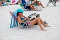 A woman sits in a beach chair reading a book at Pensacola Beach, Florida