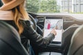 Woman sits behind wheel in car and uses electronic dashboard. Girl traveler looking for way through navigation system. Royalty Free Stock Photo