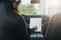 Woman sits behind wheel in car and uses electronic dashboard. Girl traveler looking for way through navigation system.