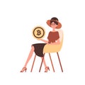 A woman sits in a chair and holds a bitcoin coin in her hands.