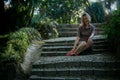 A woman sits on the cobblestone steps in an old park. Royalty Free Stock Photo