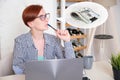 Woman sits at a desk in front of a blank sheet of paper with a red pencil Royalty Free Stock Photo