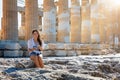 Woman sits in front of the columns of the Parthenon Temple at the Acropolis of Athens Royalty Free Stock Photo