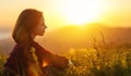 Woman sits with her back in the field and look sunset in the mountains Royalty Free Stock Photo