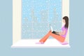 Woman sits with a laptop on the windowsill