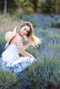 Woman sits in Lavender field, her Hair blows in Wind. Purple Lavender Bloom. Summer Evening Royalty Free Stock Photo